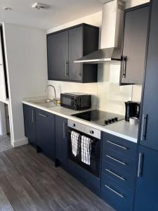 a kitchen with blue cabinets and a stove top oven at 505 Broadway residence in Bradford