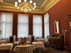 a dining room with tables and a chandelier at Lesní Mlýn Depandance in Mariánské Lázně
