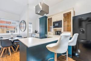 a kitchen with blue and white cabinets and white chairs at Group-Friendly, Sheffield Flat, sleeps 6 in Walkly +16 photos