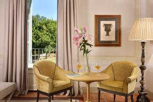 a living room with two chairs and a table with glasses of wine at Relais Sant'Uffizio in Cioccaro