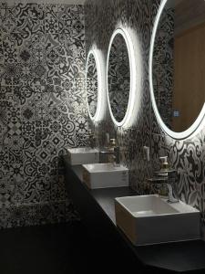 a bathroom with two sinks and two mirrors at Volcano'73 in Vestmannaeyjar