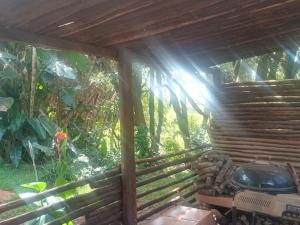 a wooden pergola with a grill in a garden at Ethlathini Rest Camp in Hluhluwe