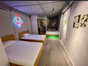 a room with two beds and a neon sign at Hanoi Harmony in Hanoi
