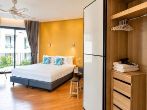 a bedroom with a bed and a desk and a refrigerator at Teetara Villa Patong in Patong Beach +77 photos