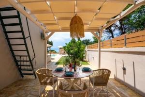 a patio with a table and chairs under a pergola at Tsanta house in Agios Gordios