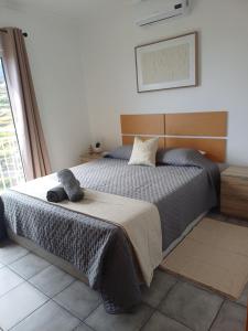 a bedroom with a bed with a gray blanket at Madeira Pura in Calheta