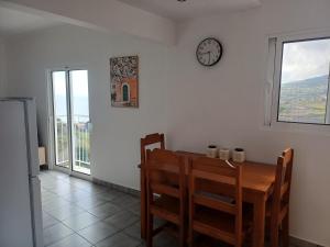 a dining room with a table and a clock on the wall at Madeira Pura in Calheta