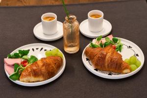 a table with two plates of food and two cups of coffee at The Square Hotel in Cluj-Napoca