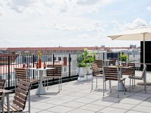 a patio with tables and chairs and an umbrella at Folk Copenhagen in Copenhagen