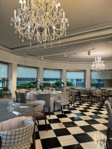 a dining room with tables and chairs and a chandelier at Hotel Restaurante El Valles 4 ESTRELLAS in Briviesca