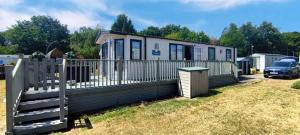 a house with a fence and a car parked at StaticCaravan-6Berth-DogFriendly in Northampton