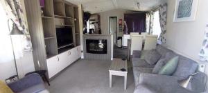 a living room with a couch and a table at StaticCaravan-6Berth-DogFriendly in Northampton