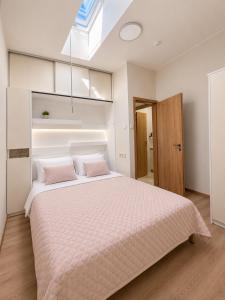 a bedroom with a large bed with pink pillows at Guest House Klevu 17 in Palanga