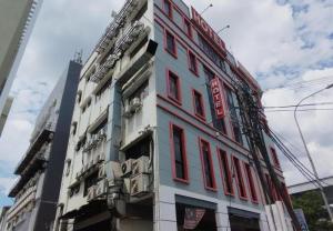 a building with red windows on a city street at Cahaya Midah Hotel (BilikXpert) in Kuala Lumpur