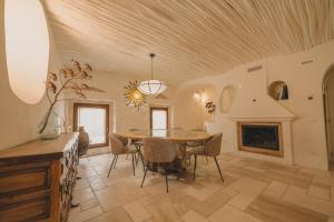 a dining room with a table and a fireplace at Hotiday Elite Olea Sanctuary in Olbia