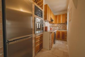 a kitchen with a stainless steel refrigerator and wooden cabinets at Hotiday Elite Olea Sanctuary in Olbia