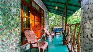 a porch of a house with chairs and a table at N S K Green Villa in Sigiriya