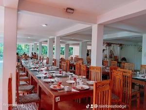 a long dining room with long tables and chairs at Rainforest Lodge, Deniyaya singheraja in Deniyaya