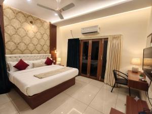 a bedroom with a large bed and a desk and a bed sidx sidx sidx sidx at Sree Durga Hotel Ramsons International in Mysore