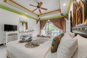 a bedroom with three beds and a ceiling fan at Le Palace hotel krabi in Ban Khlong Haeng