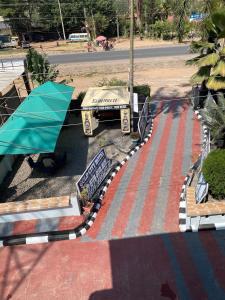 a park with benches and an umbrella on a street at New Gold city hotel in Mwanza +6 photos