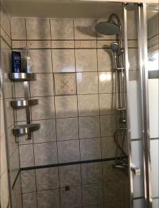 a shower in a bathroom with a tile wall at Luxury Maisonet Veranda View Batsi in Batsi +24 photos
