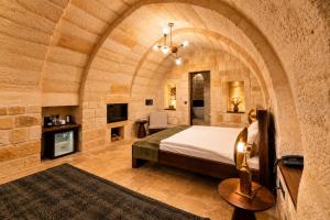 a bedroom with a bed in a stone wall at Luvi Cave Hotel in Göreme