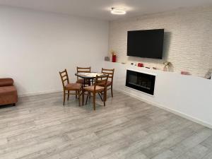 a dining room with a table and chairs and a fireplace at Lad Petite Maison in Craiova