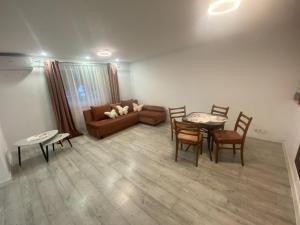 a living room with a couch and a table and chairs at Lad Petite Maison in Craiova