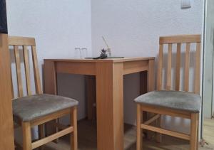 a wooden table with two chairs next to a table with at Hostel JAPI in Aleksinac