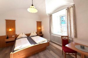 a bedroom with a bed and a table and a window at Hotel und Restaurant Römerstein in Bad Aussee