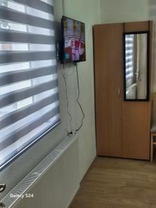 a room with a window with a tv on the wall at Hostel JAPI in Aleksinac +10 photos