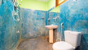 a blue bathroom with a toilet and a shower at N S K Green Villa in Sigiriya