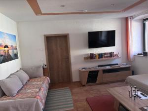 a living room with a couch and a flat screen tv at Ferienwohnung auf dem Gutshof Renz in Weißenfels