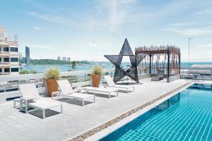 a pool with chairs and a star on top of a building at Hermann Hotel Pattaya in Pattaya