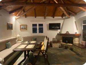 a living room with a couch and a table and a fireplace at Luxury Maisonet Veranda View Batsi in Batsi