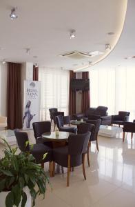 a waiting room with chairs and tables and a piano at Hotel Luna in Međugorje