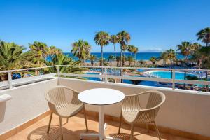 a table and chairs on a balcony with a view of the ocean at SOL by Meliá Lanzarote All Inclusive in Puerto del Carmen