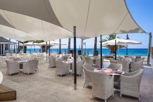 a restaurant on the beach with tables and umbrellas at SOL by Meliá Lanzarote All Inclusive in Puerto del Carmen