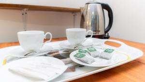 a tray with two cups and plates on a table at N S K Green Villa in Sigiriya