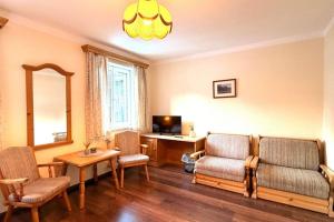 a living room with a couch and chairs and a desk at Hotel und Restaurant Römerstein in Bad Aussee