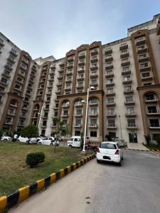 a white car parked in front of a large building at The Cubee Nest- Luxury 1BHK in Central Bahria Enclave in Islamabad