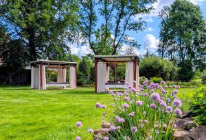 two gazebos in a field with flowers at Flair Hotel Rieckmann in Bispingen