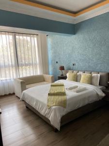 a bedroom with a large bed and a blue wall at Sky Beach Resort in Kisumu