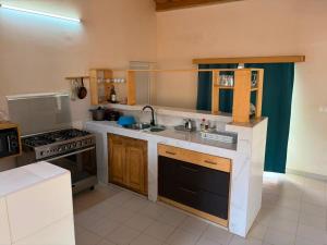 a kitchen with a sink and a stove at Le Clos Rivière in Ndangane