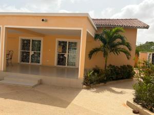 a house with a palm tree in front of it at Le Clos Rivière in Ndangane