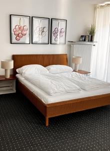 a bed in a bedroom with three pictures on the wall at Mosel-Studio-Apartment in Lieser