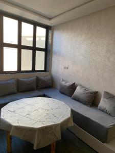 a room with a couch with a table and a window at Appartement 1 in Al Hoceïma