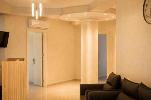 a living room with a couch and a clock on the wall at VELOR Hotel apartment in Batumi