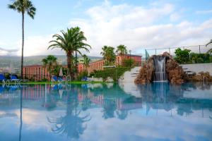 a swimming pool with a waterfall in a resort at Hotel Las Águilas Tenerife, Affiliated by Meliá in Puerto de la Cruz